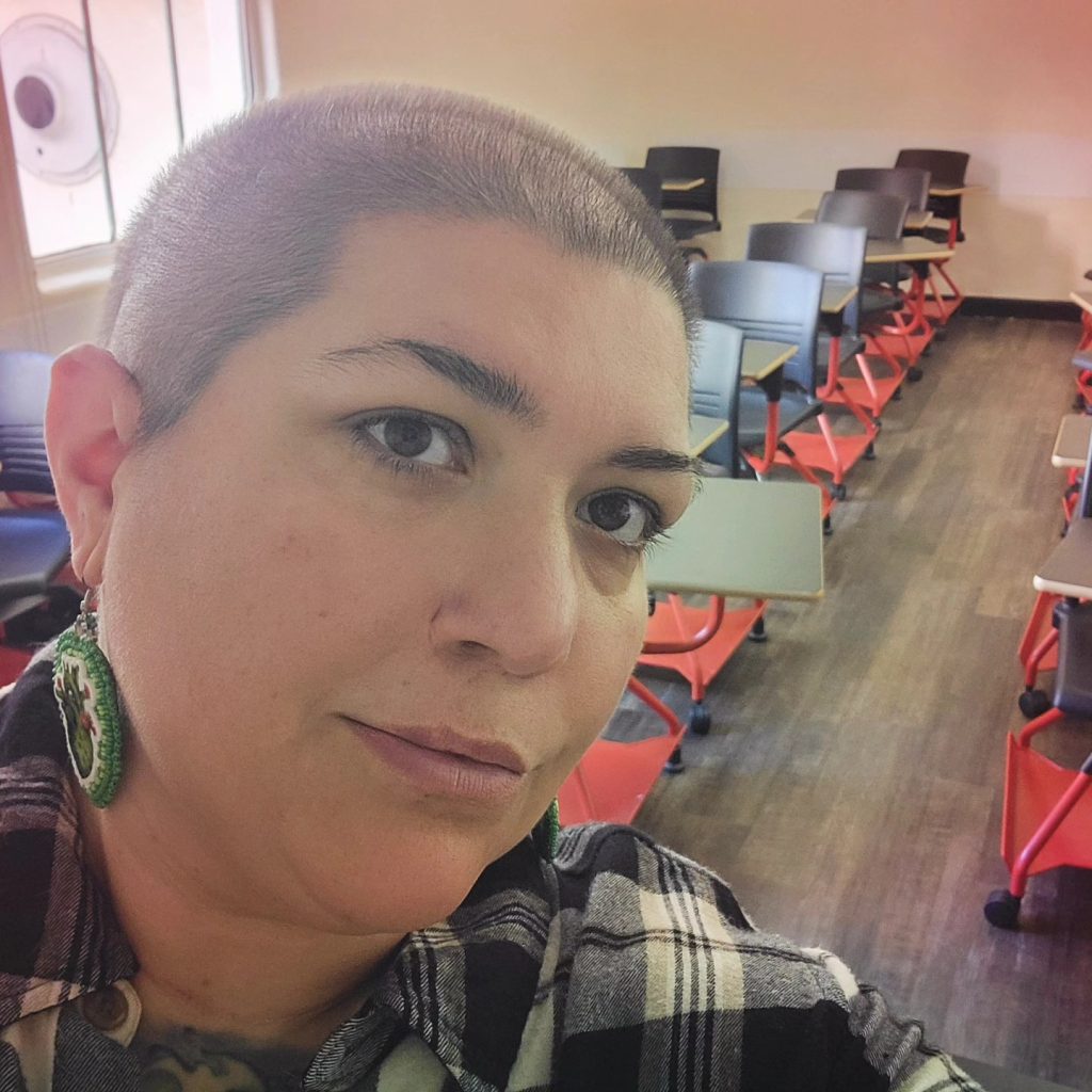 a photo of cass looking slightly above the camera, smiling with closed lips.